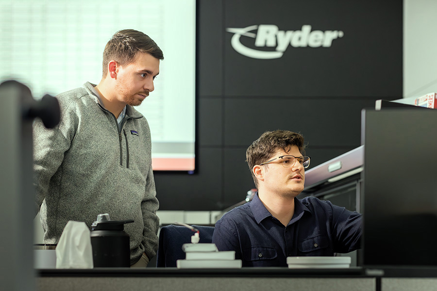 Two males looking at freight load boards